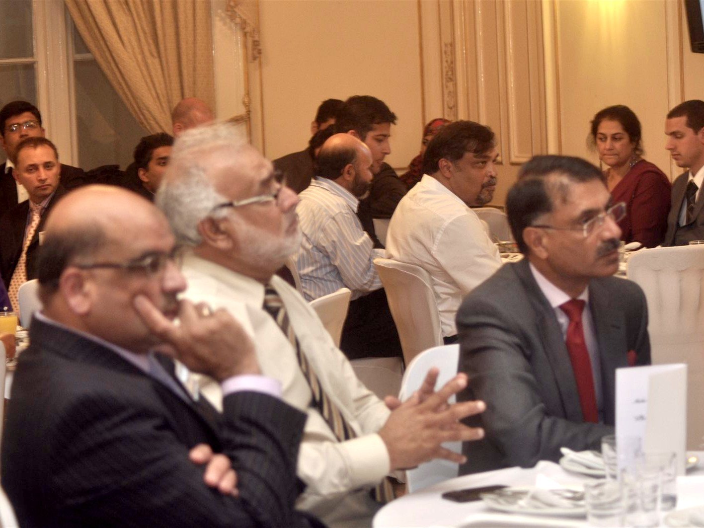 Guests seated at round tables listening to a speech