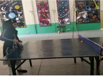 A trainee teacher playing table tennis in the college hall