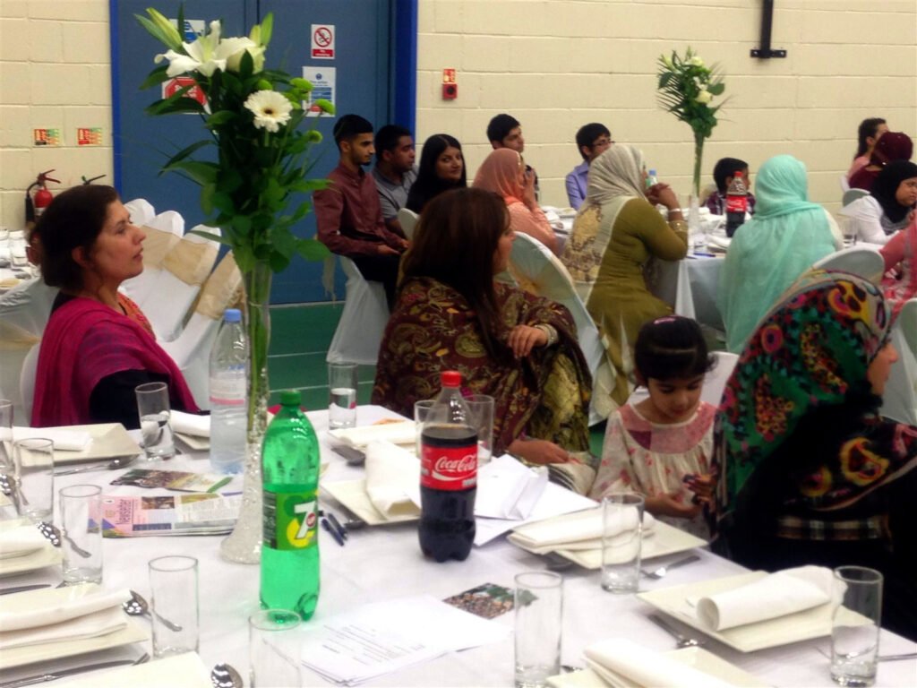 Women and a young girl seated at a dinner table with flowers
