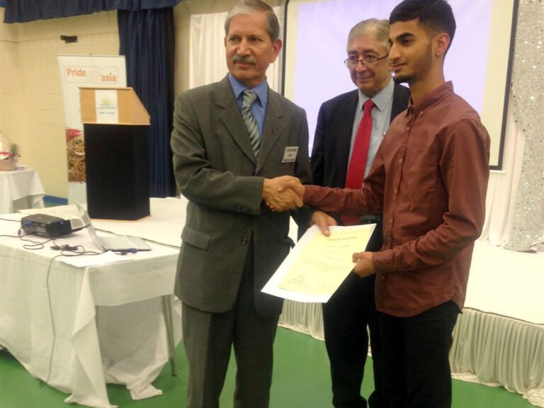 Young man receiving a Quest for Education certificate with a handshake