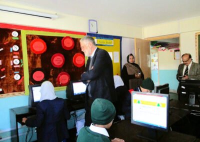 Pupils in uniform at computers in a school IT lab with our patron