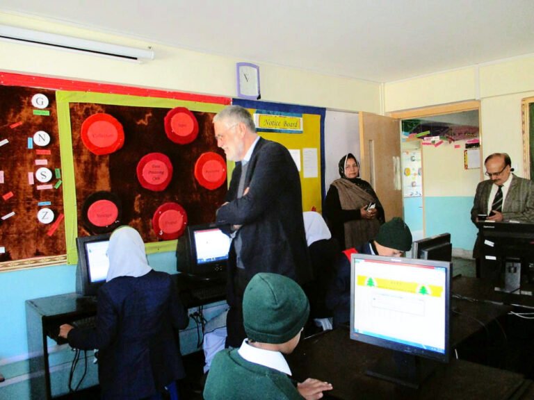 Pupils in uniform at computers in a school IT lab with our patron