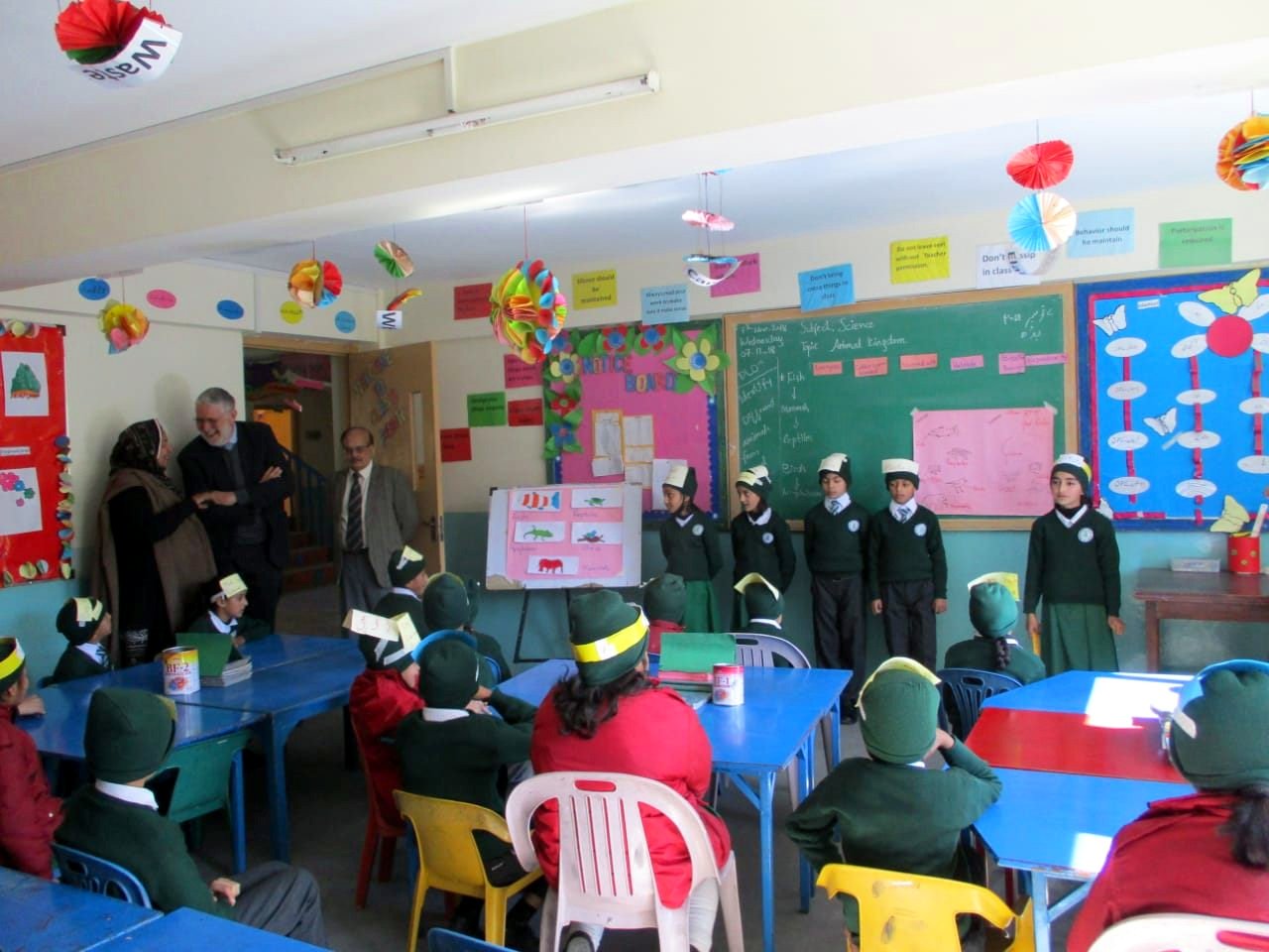 Pupils in paper hats present a science lesson about the animal kingdom
