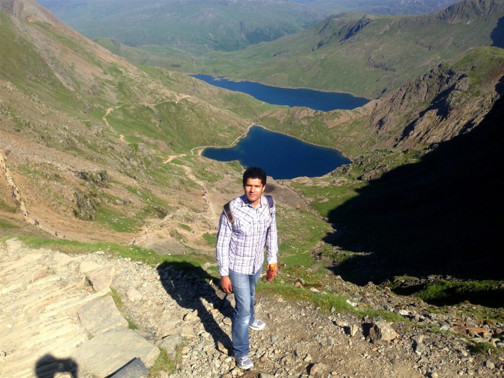 Mobeen Anwar on a path above two deep-blue mountain lakes